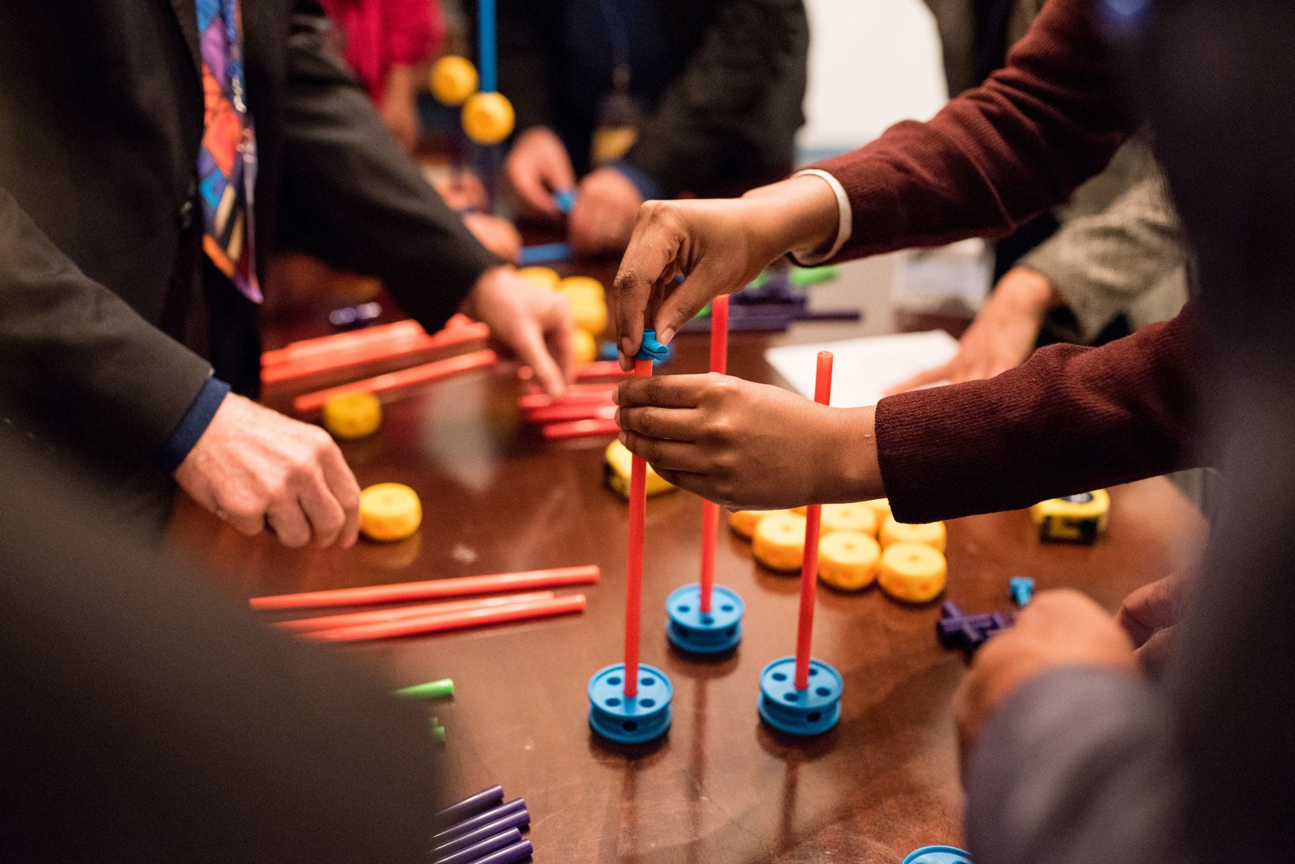 hands playing with building toys on a table