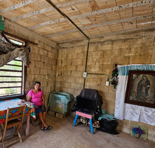 Woman sitting in a corner of a rustic house. Marisepa from the Sierra Tarahumara is the organizing center of her extended family, she manages everything from daily budgeting to coordinating care for elderly relatives.