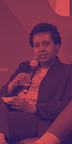 Marla Blow, CEO of the Skull Foundation, sustaining a mic in a picture with a duo tone red.