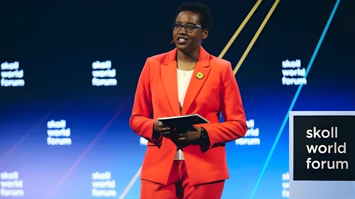 Marla Blow is wearing an orange suit on stage at the Soll World Forum in 2025.